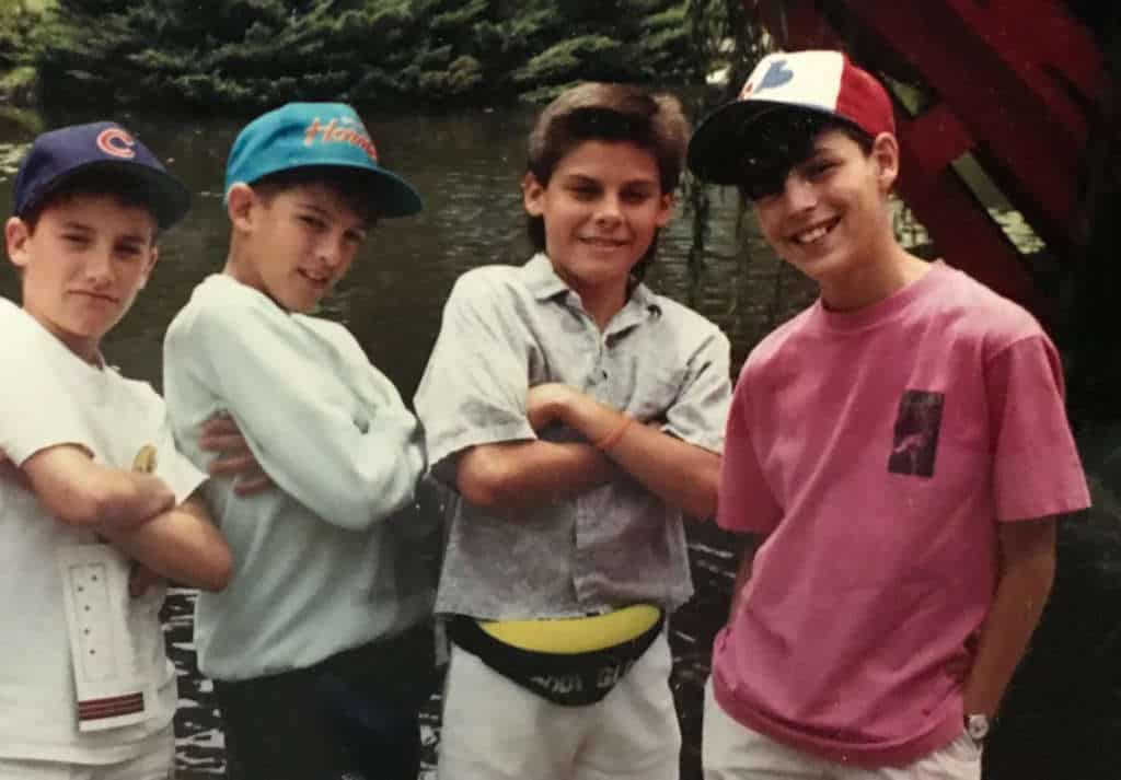 Mike Garcia as a child posing with three friends in front of a lake.
