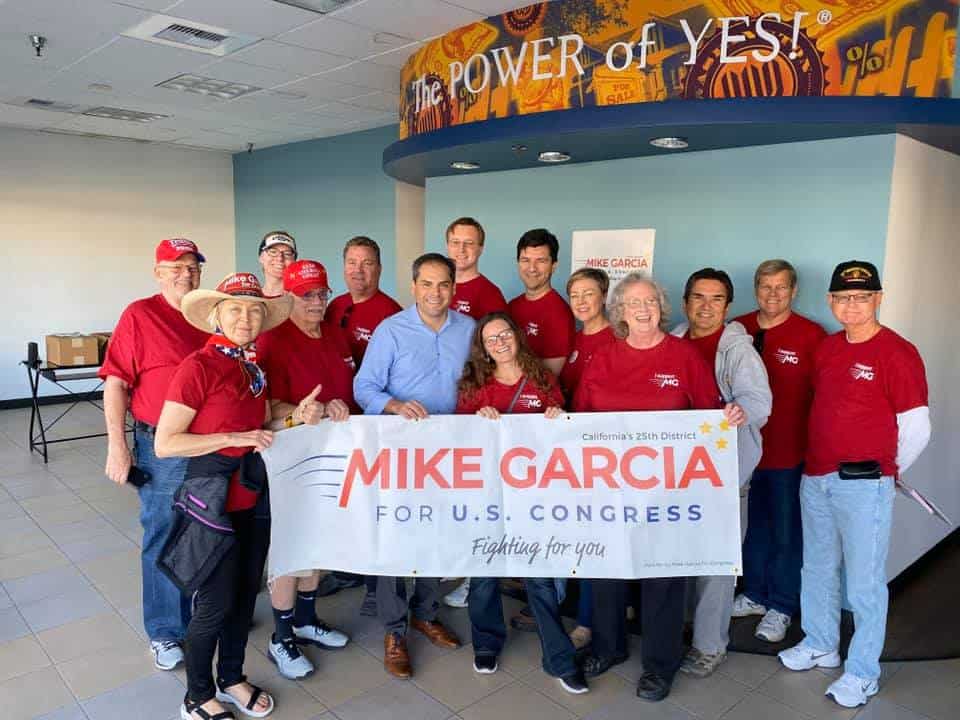 Mike Garcia with 13 volunteers holding a Garcia for Congress sign.
